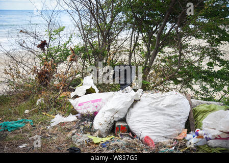 Les déchets dans la mer avec sac bouteille en plastique et autres déchets de sable de plage mer sale sur l'île / problème de l'environnement la pollution des ordures en plastique Banque D'Images