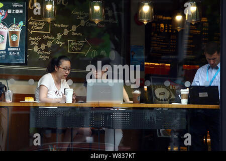 --FILE--clients déguster café et utiliser leurs ordinateurs portables dans un café de café Starbucks à Shanghai, Chine, 21 juin 2016. Plans Starbucks Corp. Banque D'Images