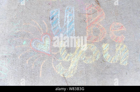 Les mots 'U' vous être écrit avec craies de trottoir sur fond des chaussées de béton gris Banque D'Images