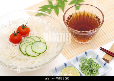 Nouilles somen japonais dans un bol en verre avec de la sauce soja sur fond blanc Banque D'Images