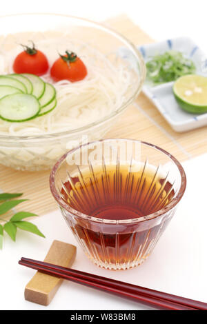 Nouilles somen japonais dans un bol en verre avec de la sauce soja sur fond blanc Banque D'Images