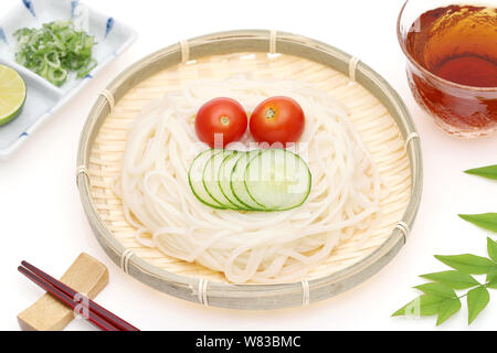 Nouilles somen japonais dans un plat en bambou avec de la sauce soja sur fond blanc Banque D'Images