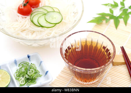 Nouilles somen japonais dans un bol en verre avec de la sauce soja sur fond blanc Banque D'Images