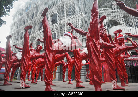 Bruce Lee rouge sculptures habillé en père Noël sont illustrés à l'extérieur d'un parc de l'industrie créative à Foshan, province du Guangdong en Chine du Sud, 21 déc. Banque D'Images