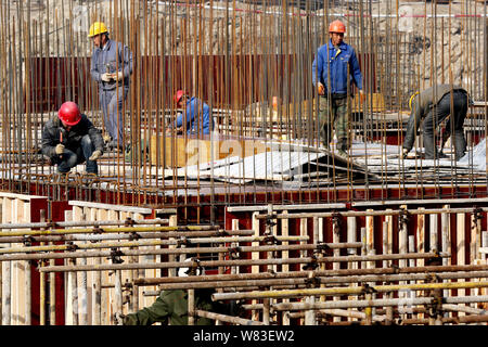 Travailleurs migrants chinois de construire une tour d'habitation sur le site de construction d'un projet immobilier résidentiel dans la région de Shanghai, Chine de l'Est Banque D'Images