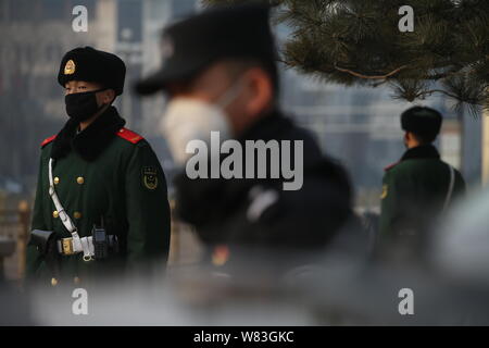 La police chinoise et les agents de police paramilitaire portant des masques contre la pollution de l'air montent la garde sur la route de lourdes le smog à Pékin, Chine, 18 D Banque D'Images