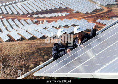--FILE--travailleurs chinois vérifier des panneaux solaires photovoltaïques à une centrale électrique dans le comté de Eryuan, préfecture autonome Bai de Dali, Yunnan du sud-ouest de la Chine Banque D'Images