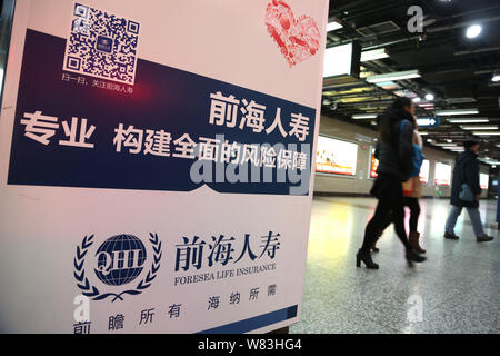 --FILE--passagers à pied passé une publicité d'Foresea l'assurance-vie (LHQ) à une station de métro à Shanghai, Chine, le 7 décembre 2014. China's insura Banque D'Images