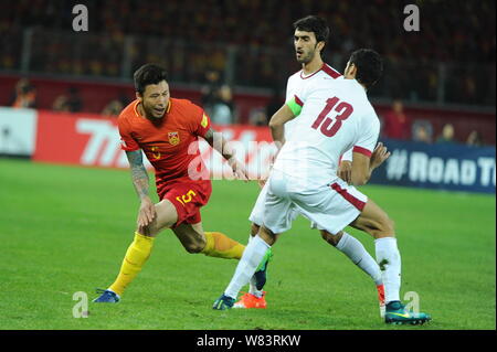 Zhang Linpeng de Chine, à gauche, les joueurs du Qatar dans leur groupe une ronde 3 match pendant la Coupe du Monde FIFA 2018 en finale de qualification asiatique Kunm Banque D'Images