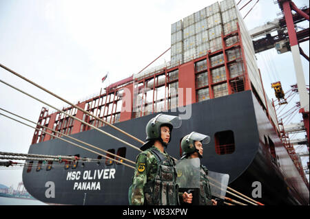 --FILE--soldats chinois montent la garde près d'un cargo chargé avec des conteneurs pour être expédiés à l'étranger, dans le port de Qingdao en Qingdao city, à l'est Chi Banque D'Images