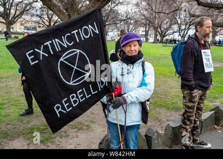 Une femme âgée avec son chien à l'extinction de rébellion protester contre le changement climatique l'inaction, à l'extérieur du Parlement de Tasmanie à Hobart, aujourd'hui (jeudi 8 août, 2019) Banque D'Images