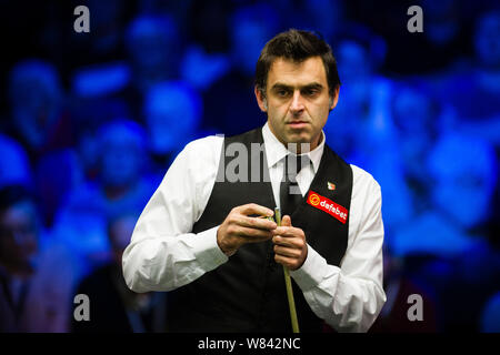 Ronnie O'Sullivan, de l'Angleterre les craies son cue qu'il estime une tourné contre John Higgins, de l'Écosse dans leur dernier match au cours de la 2016 Champion de C Banque D'Images