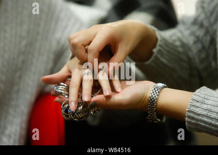 L'e-commerce chinois Miffy acheteur bijoux, droit, aide son client à essayer des bijoux conçus par elle à Shanghai, Chine, 9 novembre 2016. Miffy, un j Banque D'Images