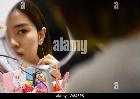 L'e-commerce chinois Miffy essaie l'acheteur bijoux boucles d conçu par sa à Shanghai, Chine, 9 novembre 2016. Miffy, une base professionnelle bijoux j Banque D'Images