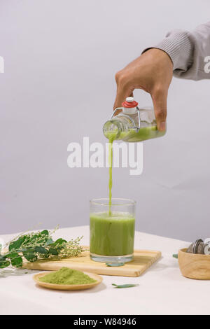 Le thé vert est versé dans le verre tasse de thé sur le tableau blanc Banque D'Images