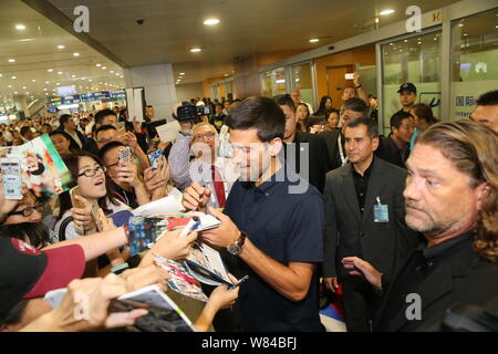 Novak Djokovic de Serbie, centre, signe des autographes pour les fans après son arrivée à l'Aéroport International de Shanghai Pudong Shanghai 2016 pour la Ma Rolex Banque D'Images