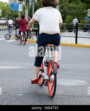 --FILE--cyclistes la bicyclette de vélo libre-service chinois Mobike sur la route de Shanghai, Chine, le 20 septembre 2016. Les deux plus grandes Chine bike-sha Banque D'Images