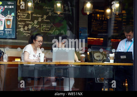 --FILE--clients déguster café et utiliser leurs ordinateurs portables dans un café de café Starbucks à Shanghai, Chine, 21 juin 2016. Plans t Starbucks Corp. Banque D'Images