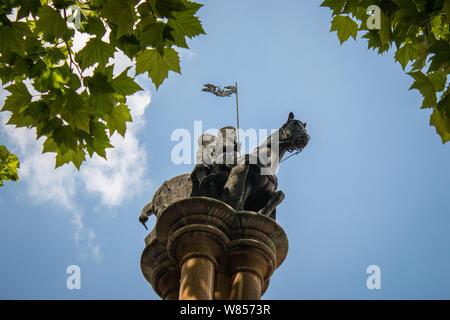 Une statue de deux hommes partageant un cheval pour représenter le voeu de pauvreté pris par les Templiers est monté en haut d'une colonne à l'extérieur de Temple Church. Banque D'Images