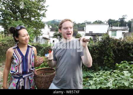 L'homme britannique Edward Gawne, droite, et sa fiancée chinoise Liao Minxin travailler dans leur potager dans Sixi Village, Wuyuan county, la ville de Shangrao, EAS Banque D'Images