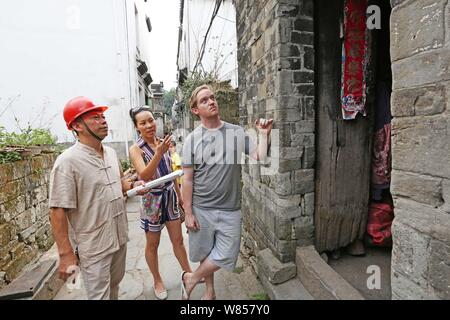 L'homme britannique Edward Gawne, droite, sa fiancée chinoise Liao Minxin, centre, et maître de sculpture chinois Yu Youhong examiner une maison endommagée par le Qin Banque D'Images