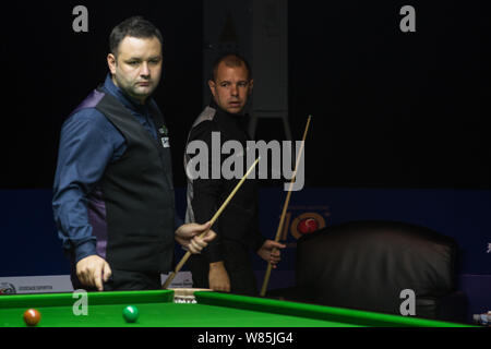 Stephen Maguire d'Écosse, gauche, estime un tir contre Barry Hawkins de l'Angleterre durant leur cycle de 16 match de la Shanghai World Snooker 2016 Banque D'Images