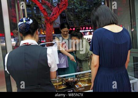 --FILE--femmes chinoises sont illustrés à l'extérieur d'une succursale de l'ICBC (Industrial and Commercial Bank of China) à Shanghai, Chine, le 4 août 2016. Wom chinois Banque D'Images