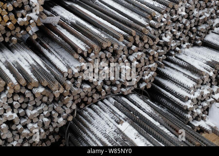 Barres de renfort en acier recouvert de neige en plein air, dans le contexte industriel, d'entrepôt, la construction d'armature. Banque D'Images