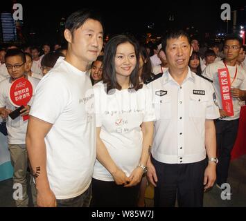 Retraite enceintes superstar tennis chinoise Li Na, centre, et son mari Jiang Shan, gauche, assister à un événement d'intérêt public pour promouvoir 'non' l'alcool au volant Banque D'Images