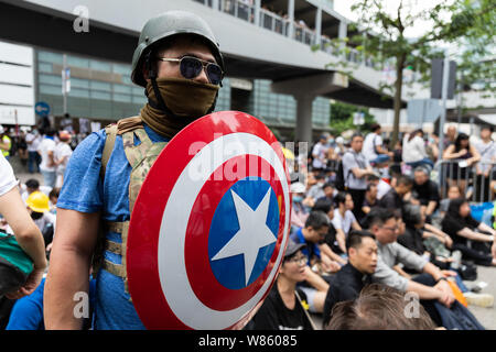 12 juin 2019 Projet de loi sur l'extradition lors d'une manifestation devant les bureaux du gouvernement du Canada en matière d'amirauté. Un manifestant vêtu d'un costume de style capitaine America, tenant un bouclier. Banque D'Images
