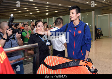 Joueur de badminton chinois Chen Long, droit, est photographié après son retour de l'Jeux olympiques de Rio 2016 à l'Aéroport International de Beijing à Beijing, C Banque D'Images