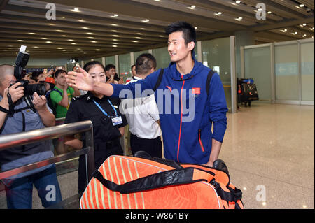 Joueur de badminton chinois Chen Long, droit, est photographié après son retour de l'Jeux olympiques de Rio 2016 à l'Aéroport International de Beijing à Beijing, C Banque D'Images