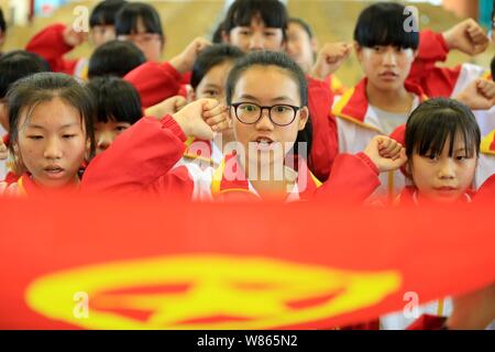 --FILE--Jeunes étudiants chinois assermenter au cours d'une cérémonie pour devenir de nouveaux membres de la Ligue de la jeunesse communiste de Chine au milieu du comté de Rongan Scho Banque D'Images