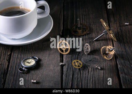 Montres Anciennes, clockwork - Engrenages, vis, une tasse de café non fini sur des planches. Bonne idée vintage, l'heure de l'intérieur. Banque D'Images