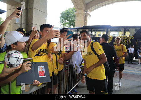 Nuri Sahin, centre, du Borussia Dortmund pose avec des fans de football chinois pour un comme lui et selfies coéquipiers arrivent à l'hôtel dans la ville de Shenzhen, au sud Banque D'Images