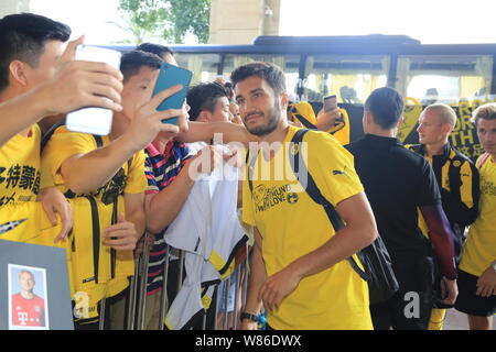 Nuri Sahin, centre, du Borussia Dortmund pose avec des fans de football chinois pour un comme lui et selfies coéquipiers arrivent à l'hôtel dans la ville de Shenzhen, au sud Banque D'Images