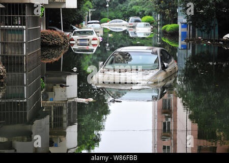 Les voitures privées sont submergées par l'eau à un quartier résidentiel gorgé à Wuhan, province du Hubei en Chine centrale, le 13 juillet 2016. La Chine a déclaré jeudi Banque D'Images