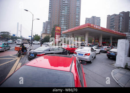 --FILE--voitures font la queue jusqu'à faire le plein à une station-service de PetroChina, filiale de la CNPC (China National Petroleum Corporation), dans la ville de Hangzhou, ea Banque D'Images