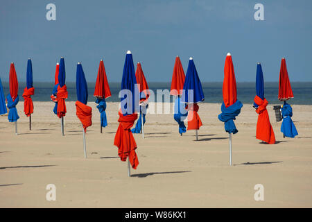 Côte Fleurie, une partie de la côte Normande : folded parasols sur la plage de Deauville (nord-ouest de la France). Banque D'Images