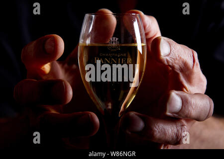 Mains tenant un verre de champagne Pannier à Château-Thierry (nord de la France) Banque D'Images