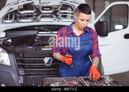 Femme travaille dans la réparation de voiture vérifier si elle dispose de tous les instruments. Banque D'Images