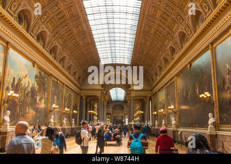 Les visiteurs d'admirer la grande peintures illustrant les succès militaires français dans la Galerie des grandes batailles dans l'aile sud du Palais de... Banque D'Images