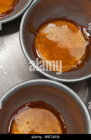 Garniture au caramel et mélanger pour crème caramel en production dans une cuisine professionnelle Banque D'Images