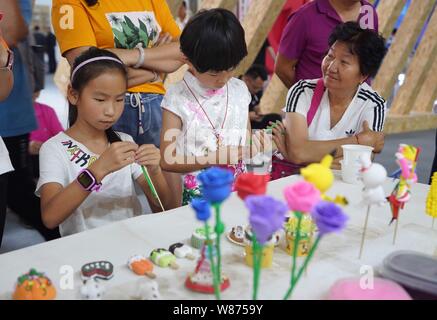 Kunming, province chinoise du Yunnan. 8e août 2019. Les enfants fabriquent des fleurs en argile au cours de la culture créative Industries Expo 2019 Yunnan à Kunming, dans le sud-ouest de la province chinoise du Yunnan, le 8 août 2019. L'expo a donné le coup d'ici jeudi. Credit : Qin Qing/Xinhua/Alamy Live News Banque D'Images