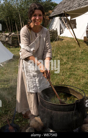 Marion, une bénévole de la Hollande, les cuisiniers des herbes pour servir à teindre dans un grand la cuisson électrique à Viking de Ribe (Danemark). Les plantes, qui sont différentes sortes de mauvaises herbes elle a trouvé à proximité, sont cuits pendant plusieurs jours. Le processus de cuisson ouvre la structure de sorte que ses plantes mélanger les produits chimiques avec l'eau. Chaque plant produit une couleur spécifique et avec toutes les plantes ensemble dans l'électrique qu'elle réalise la combinaison voulu. Dans ce cas, la couleur est vert. Banque D'Images