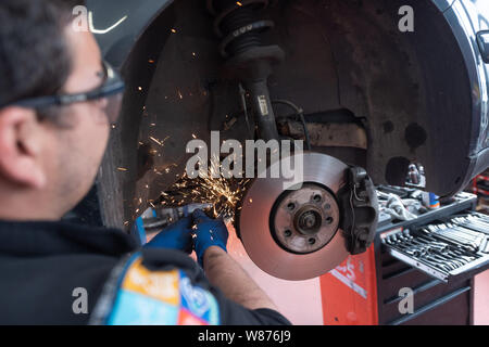 Garage : mécanique auto. Mécanicien travaillant sur une voiture, plaquettes et disques de frein. Banque D'Images