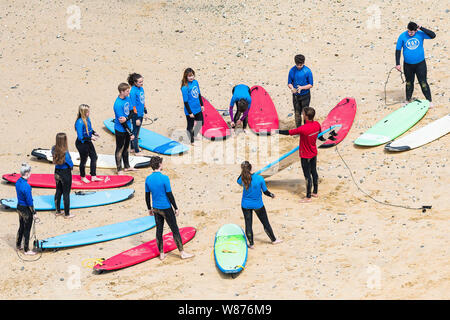 Une leçon de surf sur la grande plage de l'Ouest à Newquay en Cornouailles. Banque D'Images