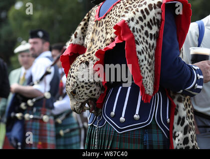 Un membre de la bande de la Touques et du District pipe band porte un tablier en peau de léopard tambour de base. Le Prince de Galles, connu sous le nom de duc de Rothesay tandis qu'en Ecosse, assiste à l'Highland Games à Ballater Monaltrie Park. Banque D'Images