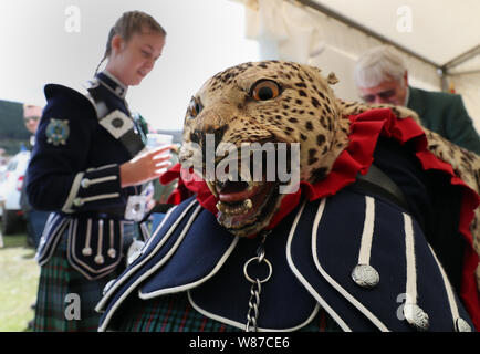 Un membre de la bande de la Touques et du District pipe band porte un tablier en peau de léopard tambour de base. Le Prince de Galles, connu sous le nom de duc de Rothesay tandis qu'en Ecosse, assiste à l'Highland Games à Ballater Monaltrie Park. Banque D'Images