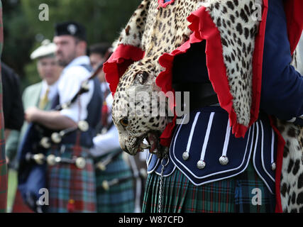 Un membre de la bande de la Touques et du District pipe band porte un tablier en peau de léopard tambour de base. Le Prince de Galles, connu sous le nom de duc de Rothesay tandis qu'en Ecosse, assiste à l'Highland Games à Ballater Monaltrie Park. Banque D'Images